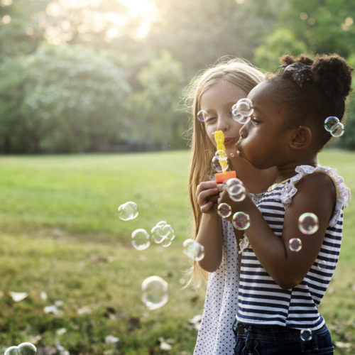 Group,Of,Diverse,Kids,Blowing,Bubbles,Together,At,The,Field